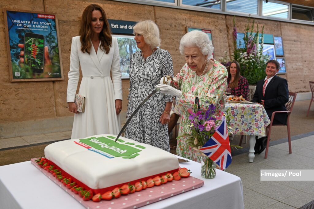 The Queen cuts cake with a sword