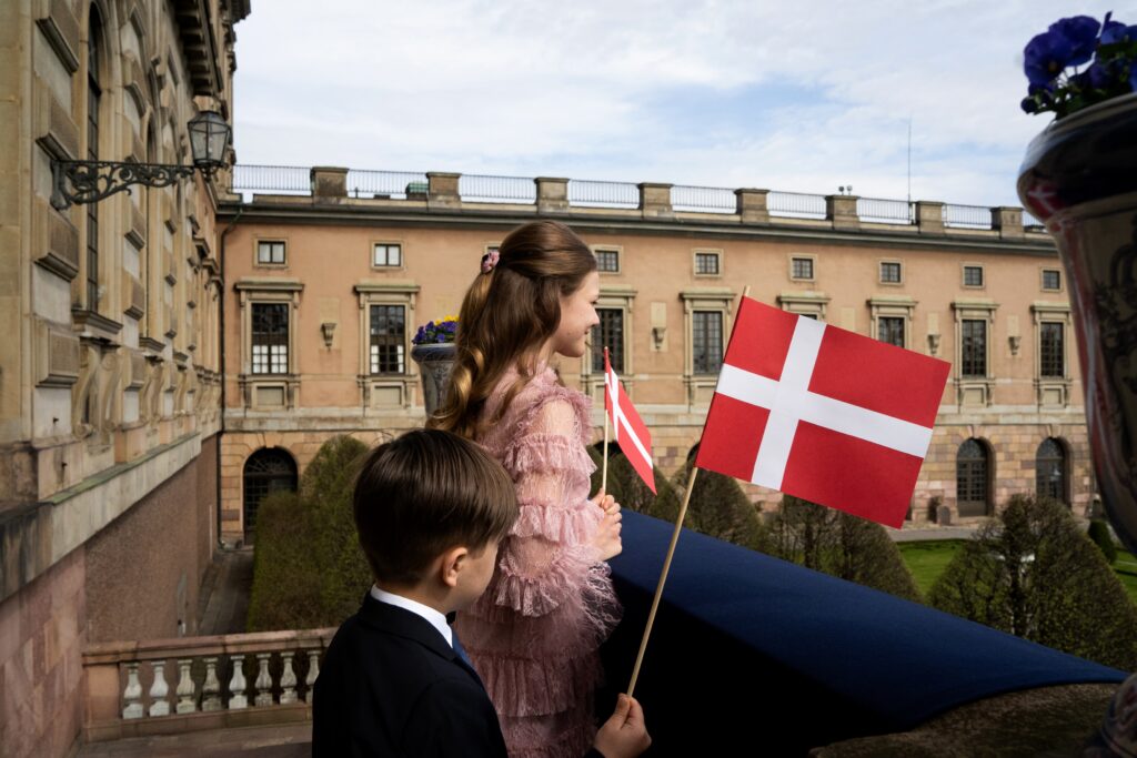 Princess Estelle and Prince Oscar of Sweden wave Danish flags to greet King Frederik and Queen Mary on their State Visit to Sweden
