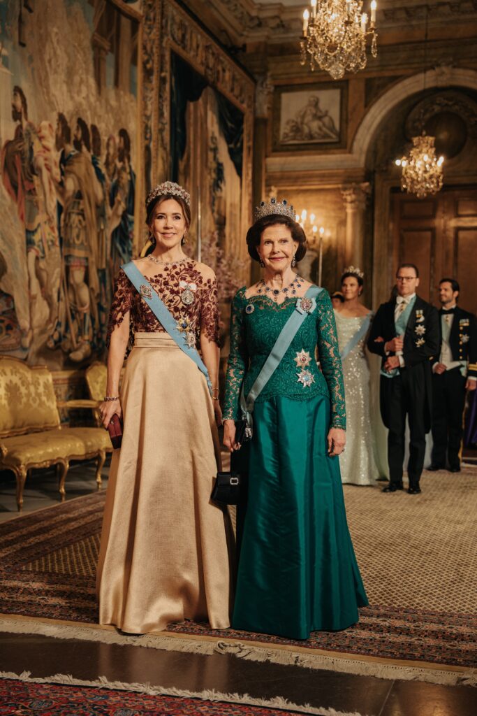 Queen Mary and Queen Silvia walk into a gala banquet during the State Visit from Denmark to Sweden