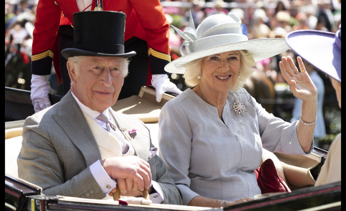 King Charles and Queen Camilla arrive at Royal Ascot by carriage. The Queen wears a grey dress and hat and a diamond brooch that once belonged to Queen Elizabeth II.