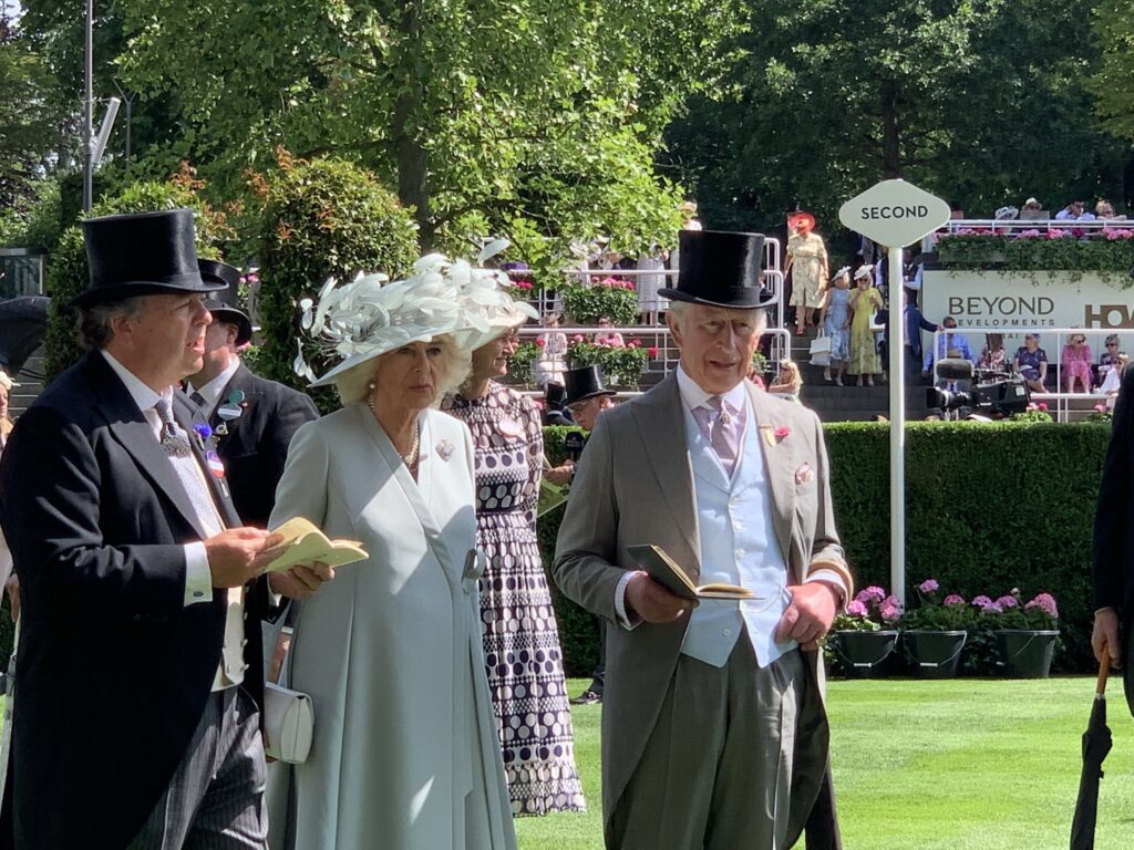 The King and Queen in the parade ring at Royal Ascot 2025. Queen Camilla is in pale sage green and wears the Cullinan V brooch