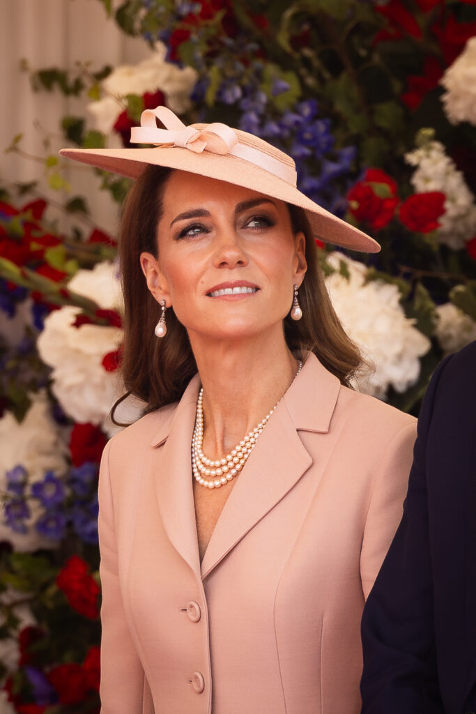 The Princess of Wales wears pale pink Dior as she stands in front of red, white and blue flowers at the official welcome at the start of the State Visit to the UK by President Macron of France