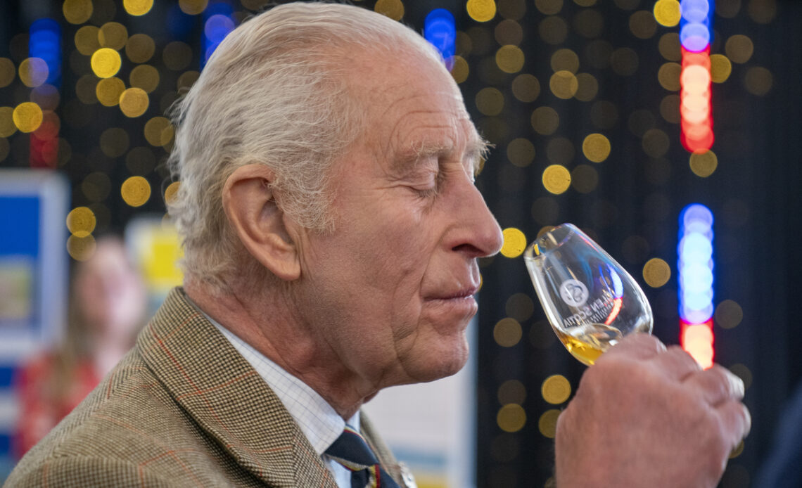 King Charles sniffs a glass of whisky before trying it during a visit to Campeltown in Scotland.