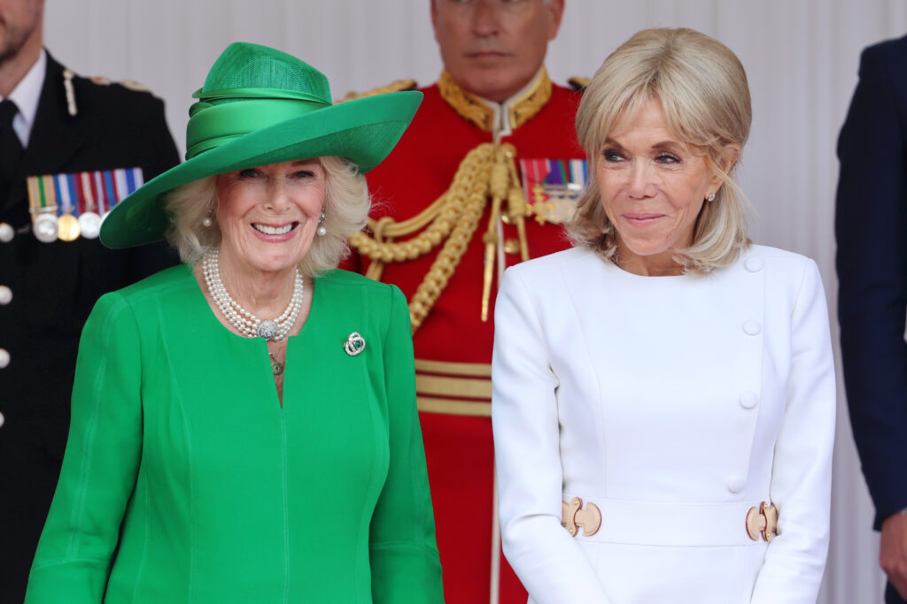 Queen Camilla and Brigitte Macron smile and chat at the start of the French State Visit to the UK. Queen Camilla wore bright green while Mrs Macron is in white.