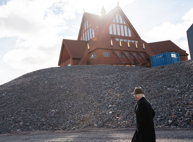 King Carl Gustaf of Sweden watches as Kiruna church is moved down the road