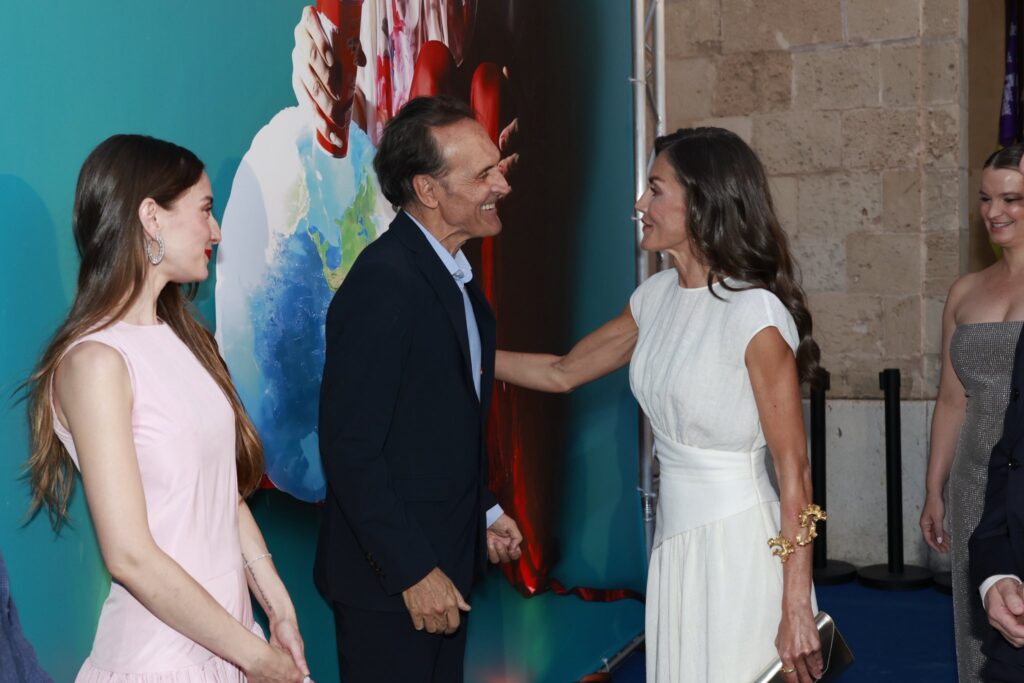 Queen Letizia of Spain wears a white dress and a large gold bracelet for a visit to a film festival in Mallorca.