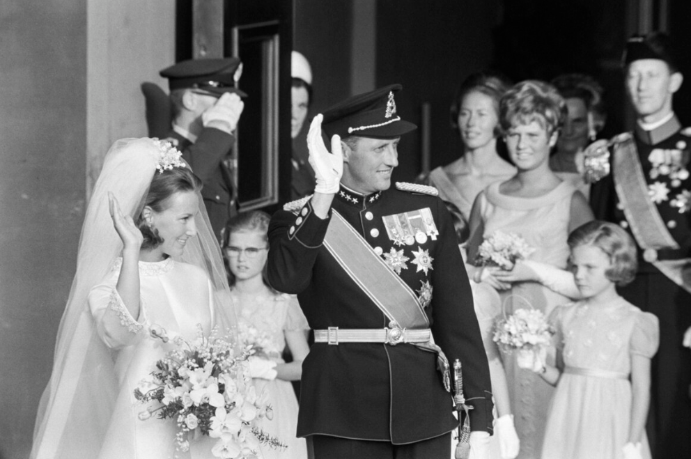 Sonja of Norway on her wedding day. She wears a white silk dress with large tulle veil held in place by fake flowers