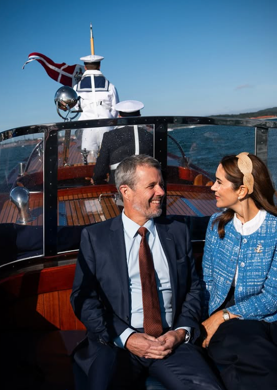 King Frederik and Queen Mary sit on a launch as they arrive for a royal tour