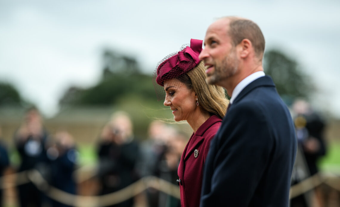 Prince William, The Prince of Wales smiles as he walks with the Princess of Wales in front of a row of photographers.