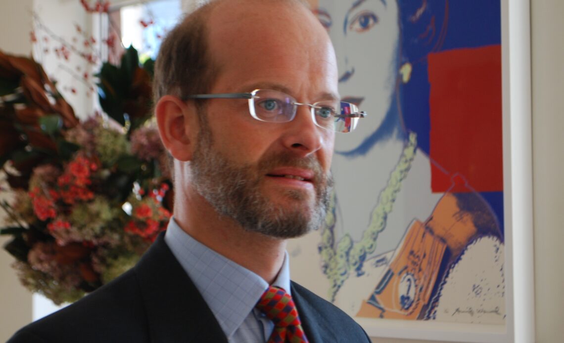 Lord Nicholas Windsor stands in front of Warhol painting of Queen Elizabeth II