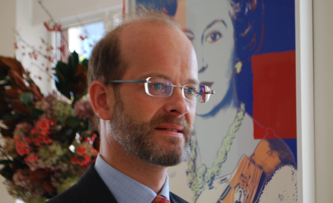 Lord Nicholas Windsor stands in front of Warhol painting of Queen Elizabeth II