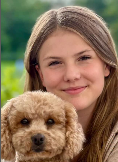 Princess Estelle of Sweden poses for a photo cuddling her pet dog
