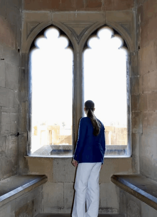 Princess Leonor, Princess of Asturias, looks through the arched windows of a medieval tower