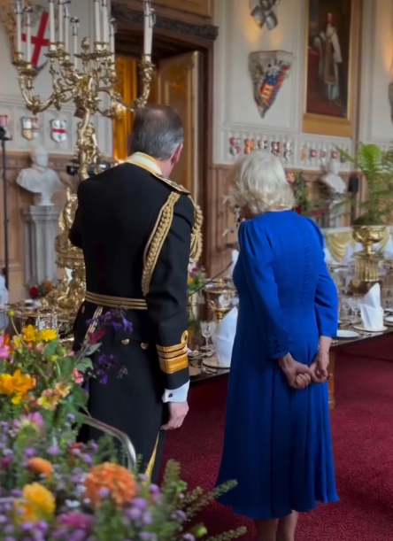 Queen Camilla, dressed in royal blue, inspects the flowers for the State Banquet