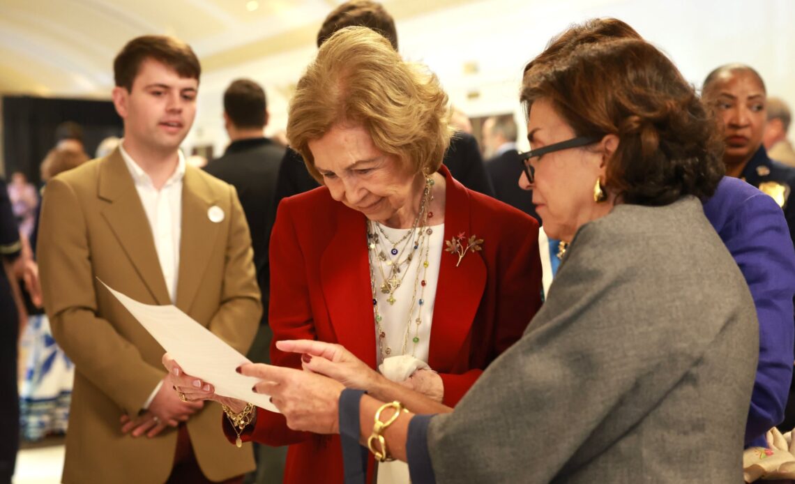 Queen Sofia of Spain looks at a paper being shown to her during a conference in Washington D.C.