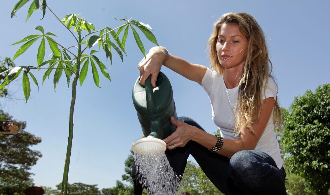 Gisele Bundchen waters a plant
