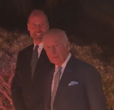 Prince William smiles as King Charles walks in front of him at a reception for COP30