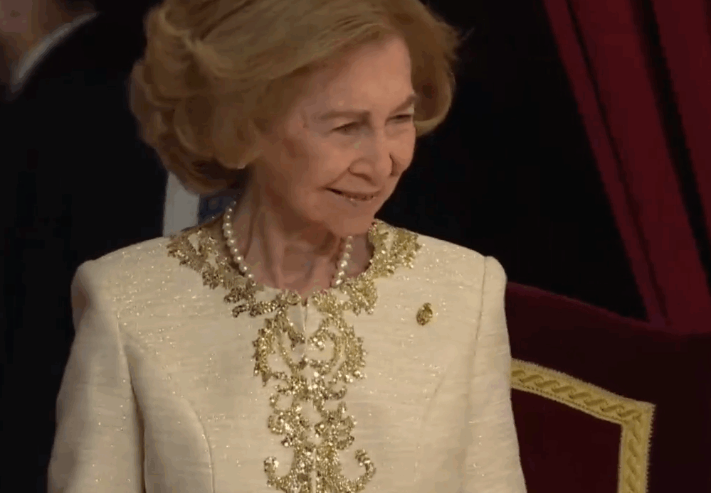 Queen Sofia of Spain in a cream coloured jacket with gold piping