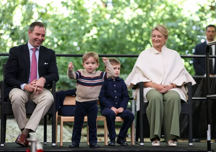 Prince Francois of Luxembourg, in a beige and blue jumper, joins in dancing