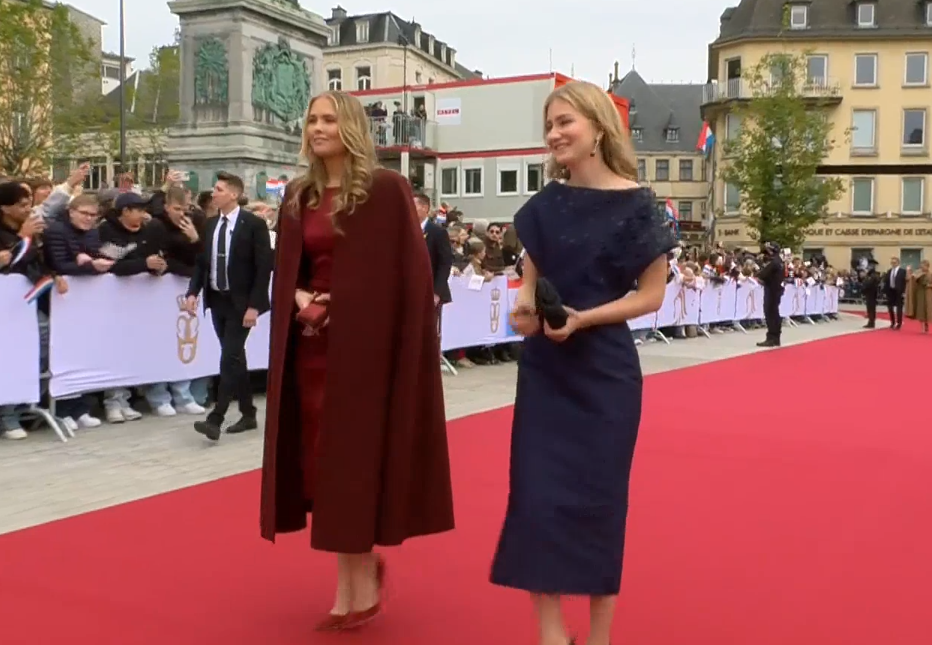 Princess Elisabeth of Belgium wears a navy dress and Princess Amalia wears a burgundy coat and gown as they attend the accession celebrations of Grand Duke Guillaume of Luxembourg