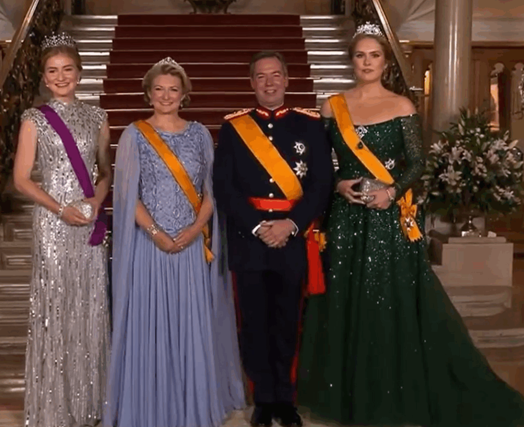 Luxembourg's new ruler in military uniform stands with his wife who is in blue and wears a diamond tiara
