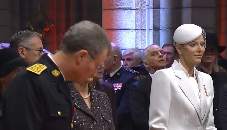 A man bows to Princess Charlene of Monaco as she walks into a church