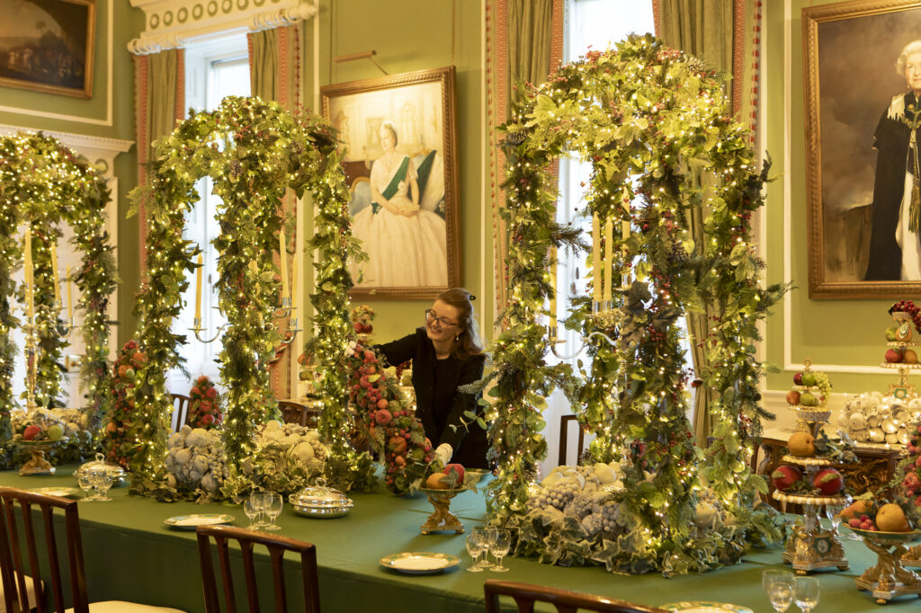 A dining table at Holyroodhouse is dressed with green and white floral garlands