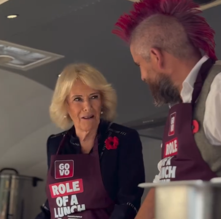 Queen Camilla chats to Spudman as they prepare jacket potatoes in a food van