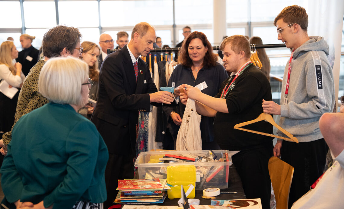 The Duke of Edinburgh sorts out clothes for a charity shop