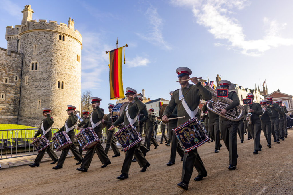 Troops march past a German flag outside the Round Tower at Windsor Castle