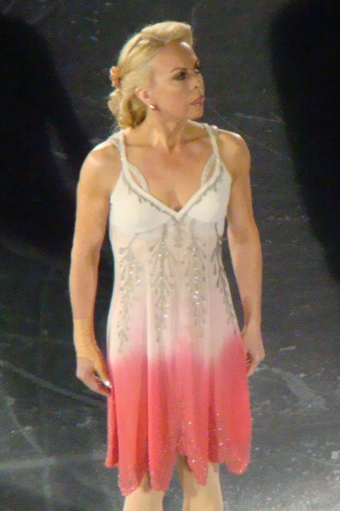 Dame Jayne Torvill wears a white and peach dress