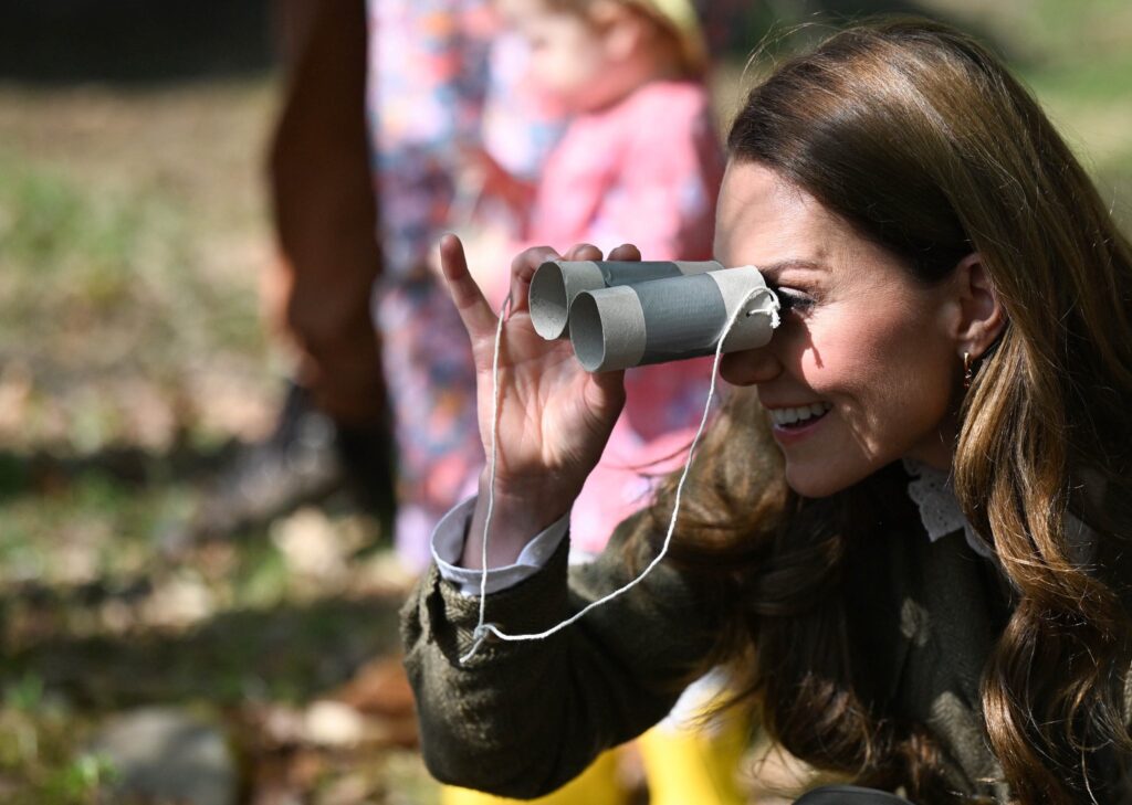 Kate, The Princess of Wales looks through cardboard binoculars