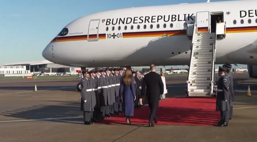 The Prince and Princess of Wales stand in front of a plane