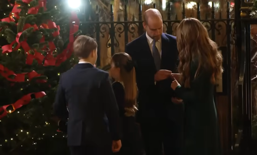 Prince William takes a piece of paper from the Princess of Wales