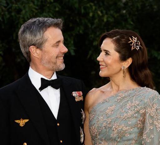 Queen Mary smiles at King Frederik as they walk in a garden in Canberra