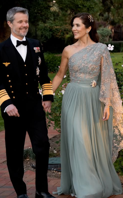 King Frederik and Queen Mary walk hand in hand in the gardens of Government House in Canberra