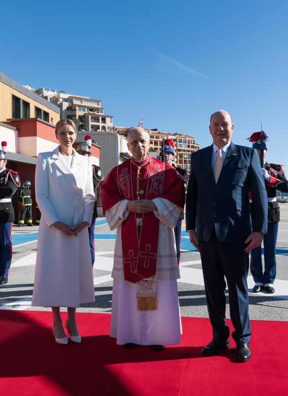 Pope Leo stands between Princess Charlene of Monaco, in a white dress, and Prince Albert of Monaco, in a dark suit