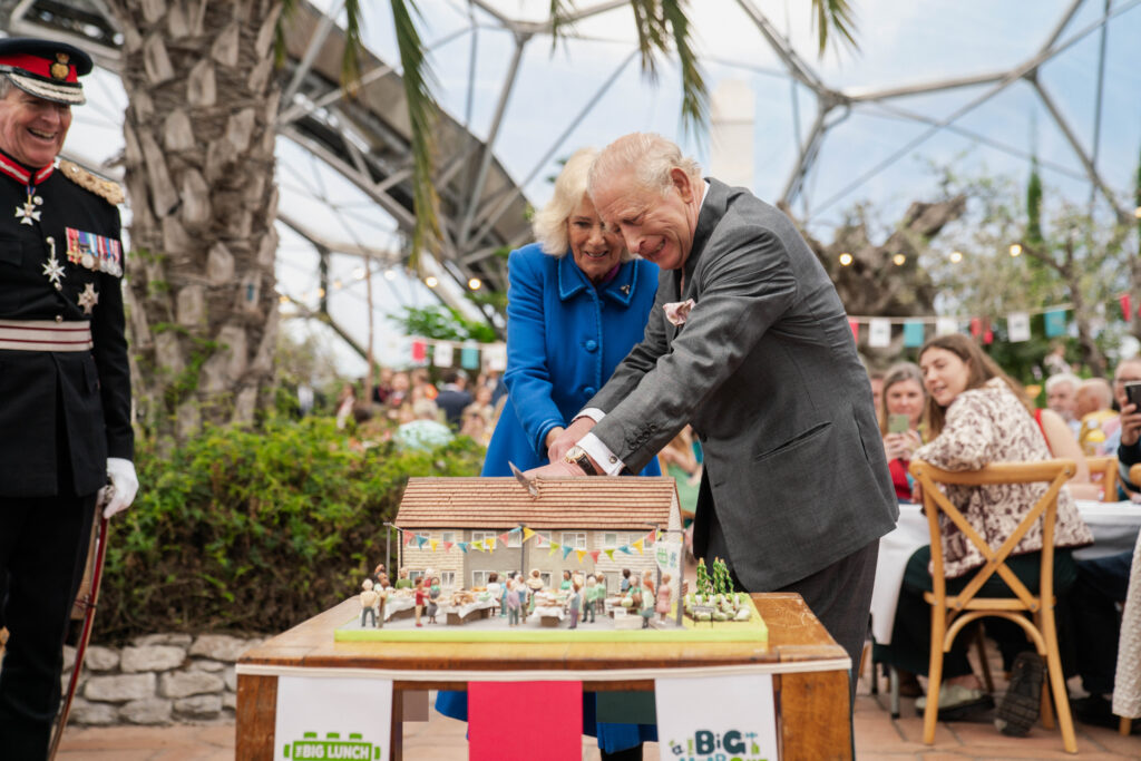 King Charles and Queen Camilla use a sword to cut a cake at the Eden Project in Cornwall