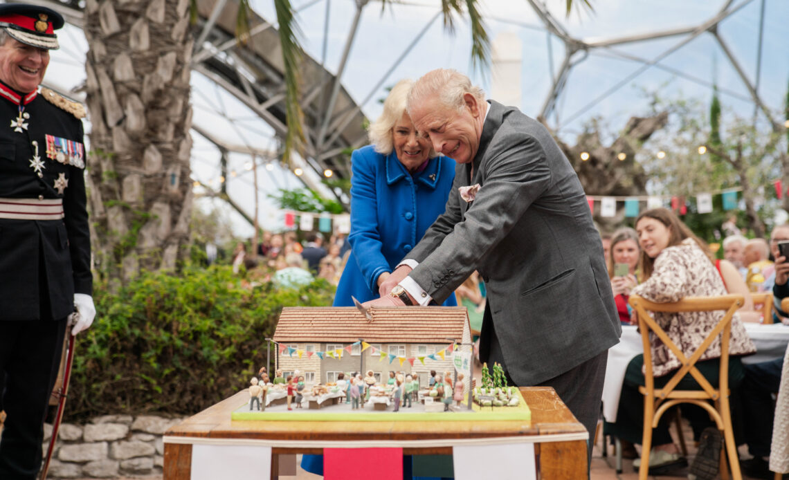 King Charles and Queen Camilla use a sword to cut a cake at the Eden Project in Cornwall