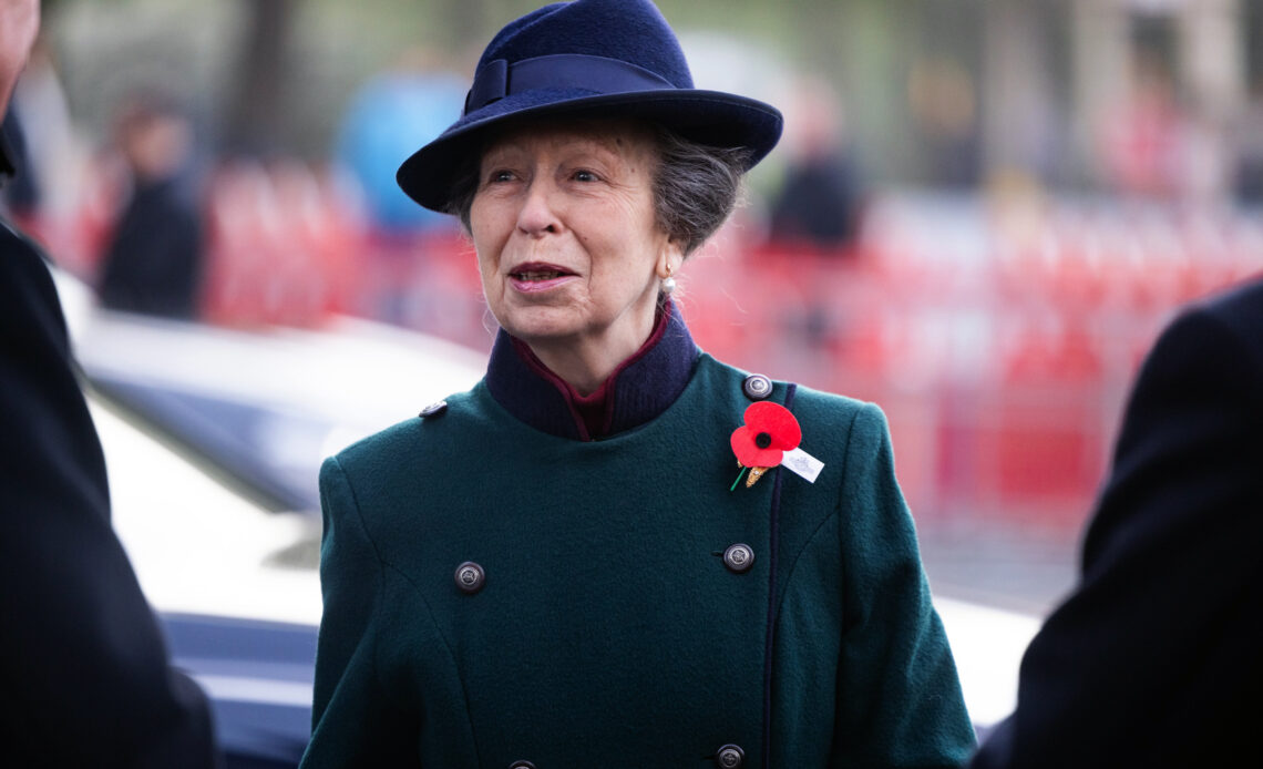 Princess Anne wears a green coat with a red poppy