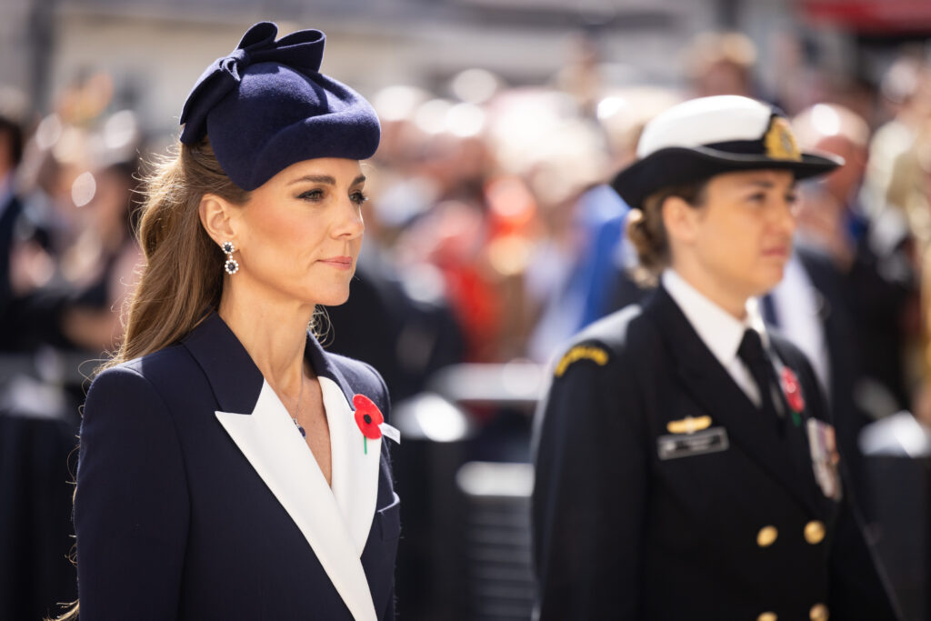 The Princess of Wales wears a navy coat with white lapels and a red poppy