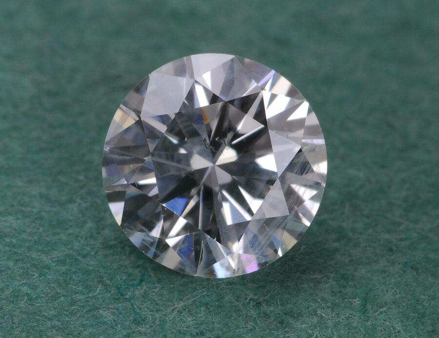 A round diamond is placed on a plain surface