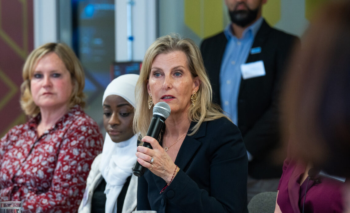 The Duchess of Edinburgh, wearing a black jacket, speaks into a microphone