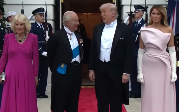 Queen Camilla wears a pink dress with bright purple stones