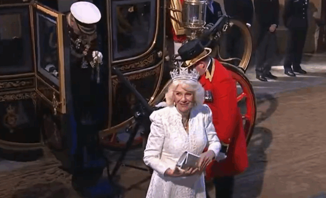 Queen Camilla wears a white dress and diamond tiara