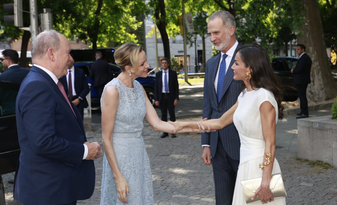Princess Charlene holds the arm of Queen Letizia of Spain